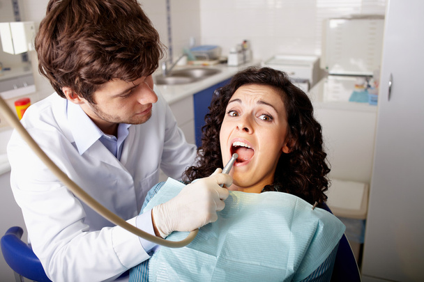 Verängstigter Patient in Zahnarztpraxis lässt Zähne untersuchen - Foto, Bild