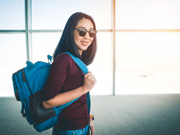 旅行し、冒険の旅を平面上を取得する準備ができての空港でアジアの女性. - 写真・画像