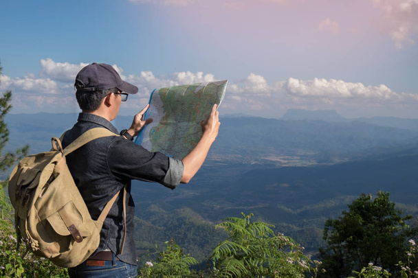 Mladý muž turistické mapy batoh relaxační venkovní s rocky - Fotografie, Obrázek