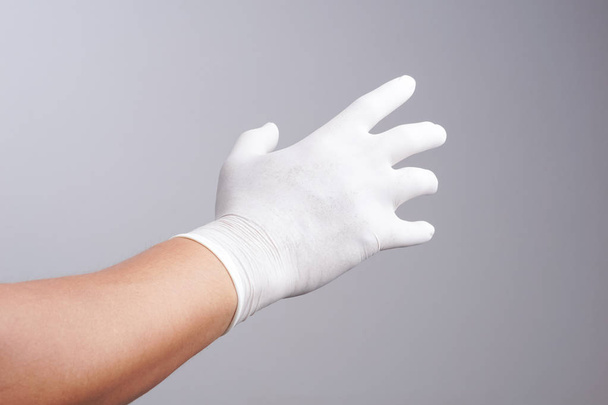 Hand dragen van latex handschoen - Foto, afbeelding