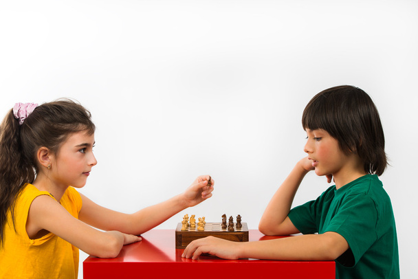 Two children playing chess isolated on white background - Photo, Image