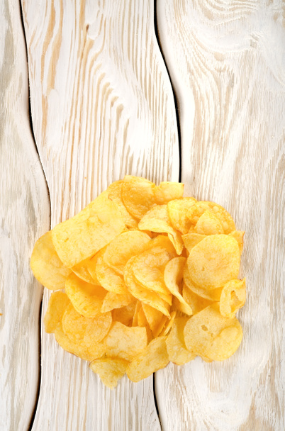 Potato chips on a white table - Fotó, kép