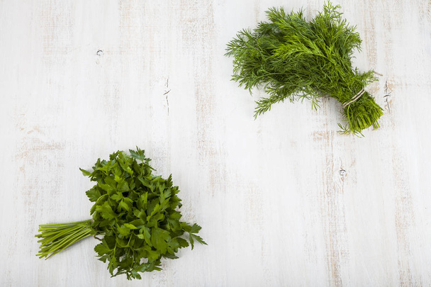 Parsley and dill on a light wooden background. - 写真・画像