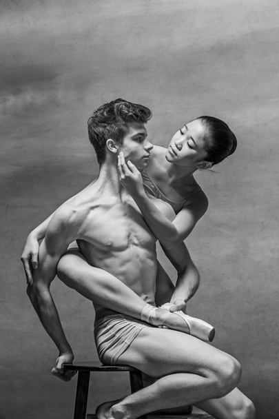 Couple of ballet dancers posing over gray background - Фото, зображення