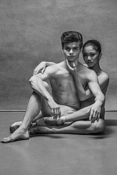 Couple of ballet dancers posing over gray background - Photo, Image