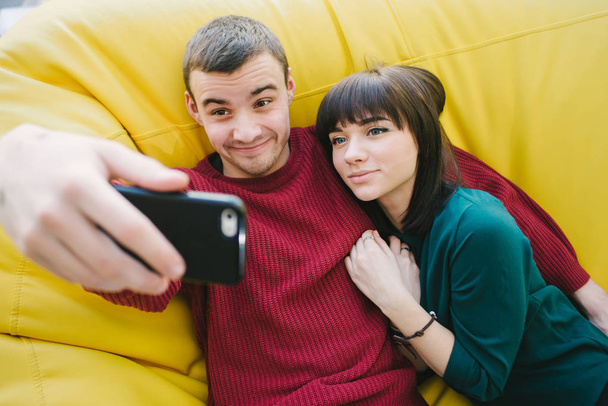 Genç bir çift aşk hipster eğlenceli selfie smartphone üzerinde yapıyor. Genç kişinin de portresi. - Fotoğraf, Görsel