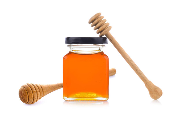 Honey with wooden honey dipper on jar - Photo, Image