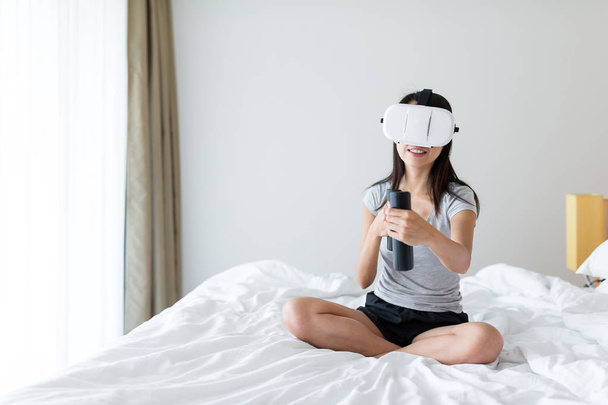 Mujer jugar con dispositivo VR en la cama
 - Foto, imagen