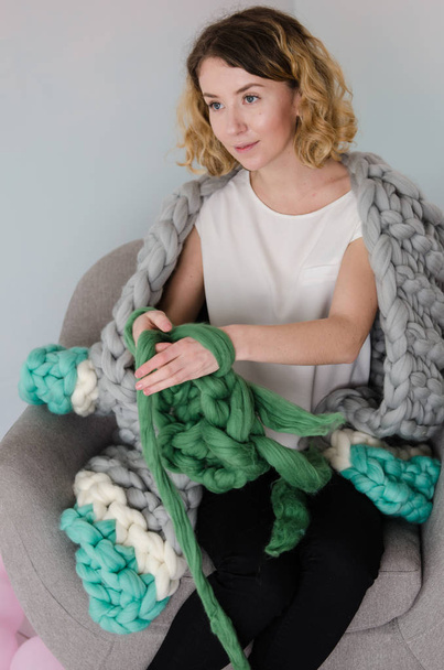 Jovem mulher sentada e tricô com lã merino
 - Foto, Imagem