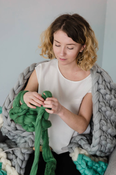 Young woman sitting and kniting with merino wool - Φωτογραφία, εικόνα