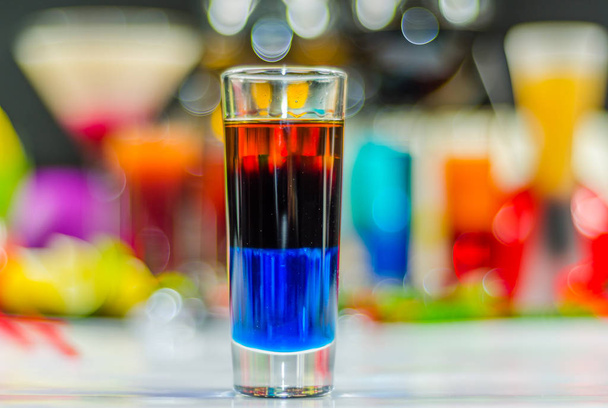 χρωματιστό ποτό στο γυαλί για τους πυροβολισμούς, ένας συνδυασμός του μπλε με το κόκκινο - Φωτογραφία, εικόνα