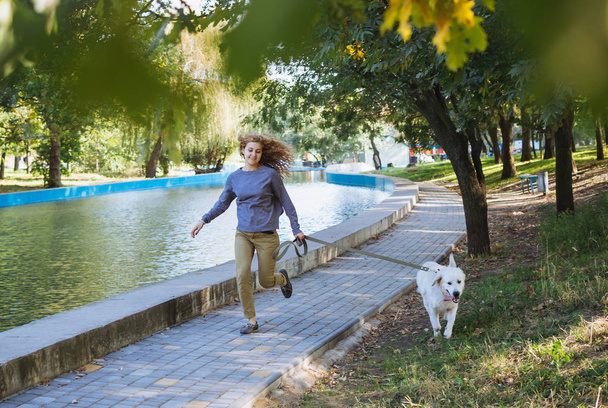 female running with dog in park - Fotoğraf, Görsel