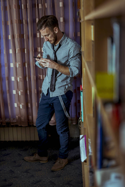 Junger Mann mit Smartphone im Büro - Foto, Bild