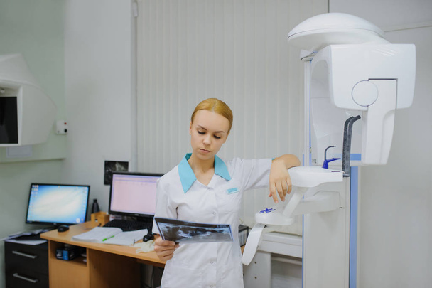 стоматолог аналізує панорамну рентгенівську плівку
 - Фото, зображення