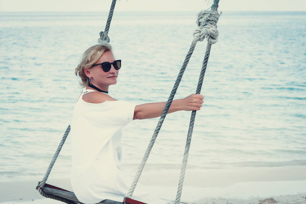 Happy woman relaxing with hanging swing on tropical beach - Zdjęcie, obraz