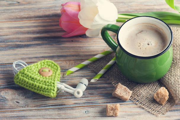 Auricolari e tazza di caffè con tulipani
 - Foto, immagini