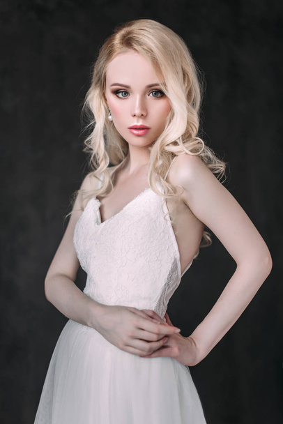 Portrait of a beautiful blond girl in image of the bride . Beauty face. Photo shot in the Studio on a grey background - Φωτογραφία, εικόνα