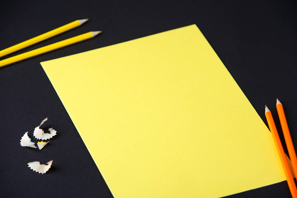 Pencil, shavings and yellow blank paper on dark background, business, design, school, office - Foto, imagen