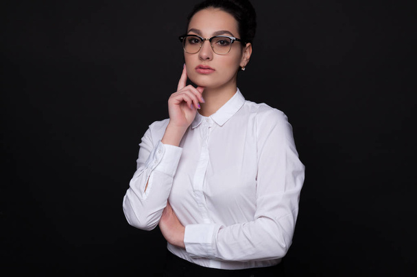 Brunette woman in black glasses on a black background - Фото, зображення