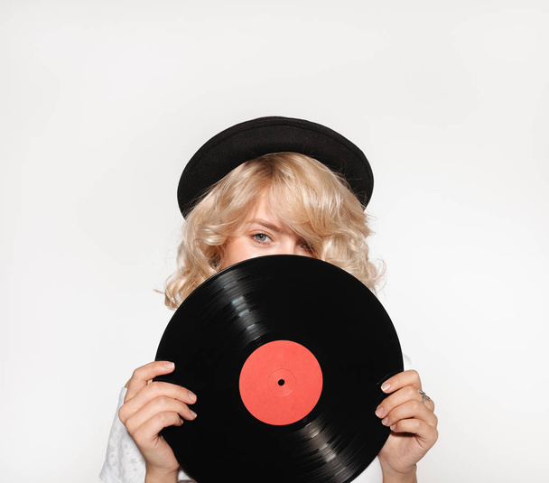 Woman closing face with vinyl record - Fotó, kép