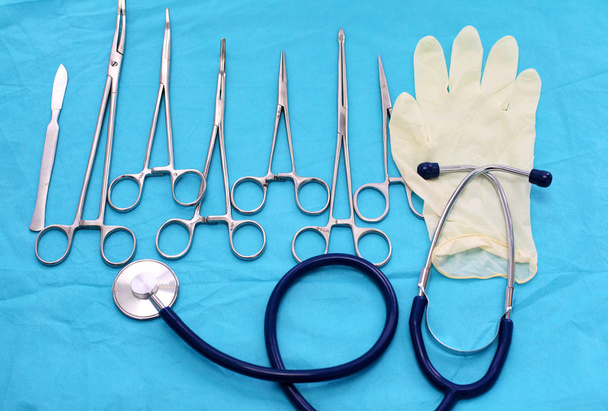 Instruments et outils chirurgicaux, y compris scalpels, pinces et pinces à épiler, disposés sur une table pour une intervention chirurgicale - Photo, image