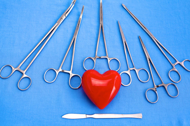 Instrumentos y herramientas quirúrgicas, incluidos bisturíes, pinzas y pinzas dispuestas en una mesa para una cirugía - Foto, Imagen