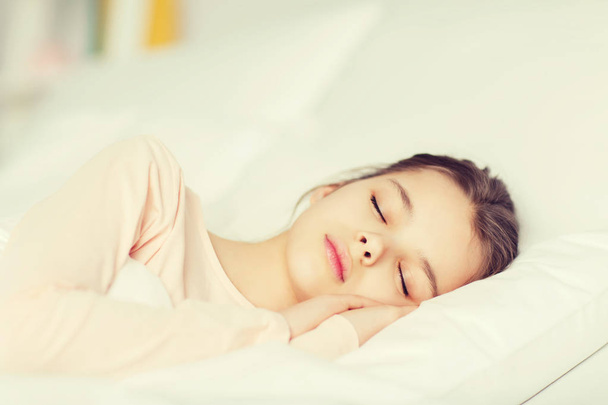 Menina dormindo na cama em casa
 - Foto, Imagem