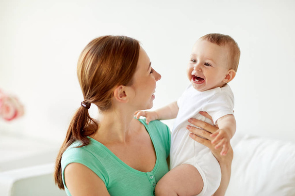 happy young mother with little baby at home - 写真・画像