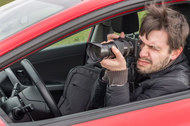 Acechador o paparazzi está tomando una foto con la cámara del coche
. - Foto, Imagen