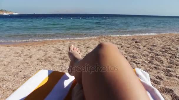 jalat makaavat aurinkotuolilla rannalla
 - Materiaali, video