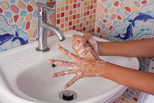 cloes hasta de mano chica lavado mano con jabón en inodoro
 - Foto, Imagen