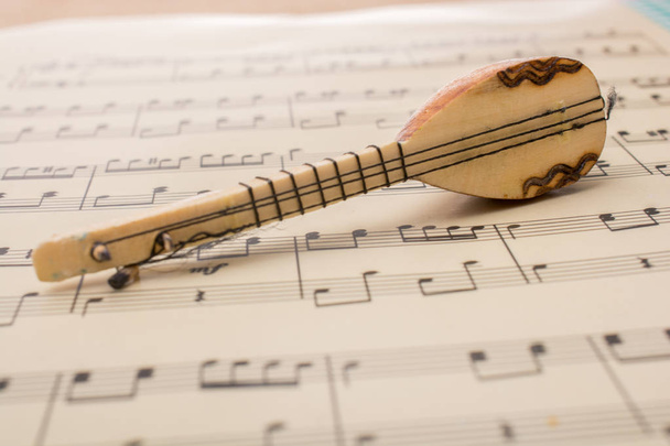 Μοντέλο του saz Τουρκικό μουσικό όργανο σε μουσικές νότες - Φωτογραφία, εικόνα