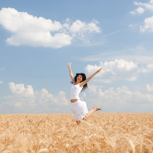 Onnellinen nainen hyppää kultainen vehnä
 - Valokuva, kuva