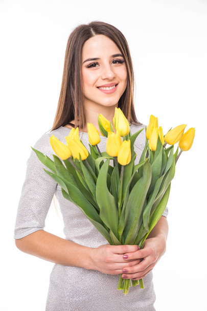 Šťastná žena v šatech s žluté tulipány izolovaných na bílém pozadí - Fotografie, Obrázek