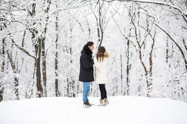 Fiatal pár átölelve és megcsókolta a parkban, télen. - Fotó, kép