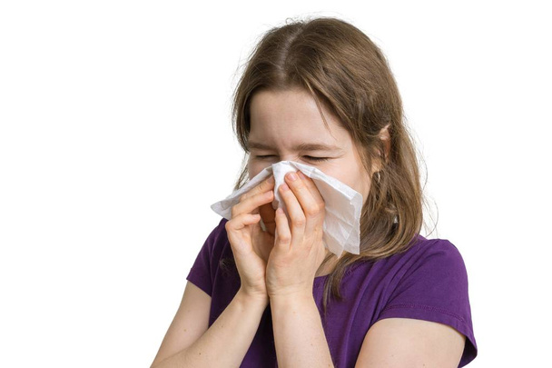 Αλλεργία έννοια. Νεαρή γυναίκα αλλεργική φτέρνισμα και φυσώντας τη μύτη της. Απομονωμένα σε λευκό φόντο. - Φωτογραφία, εικόνα