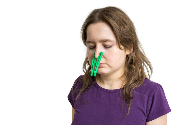 花粉アレルギーの概念。若い女性傾ける呼吸し、彼女の鼻に釘身に着けています。白い背景に分離. - 写真・画像