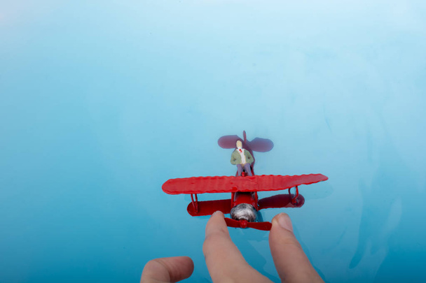 Αεροπλάνο μοντέλο και ένα ειδώλιο άνδρα στο νερό - Φωτογραφία, εικόνα