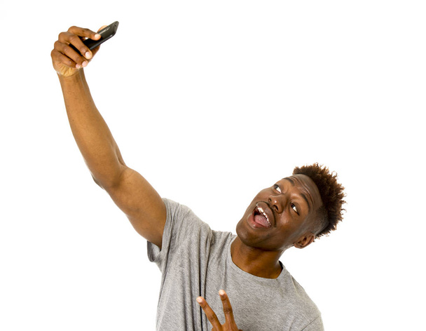joven afroamericano hombre sonriendo feliz tomando foto autorretrato selfie con teléfono móvil
 - Foto, imagen