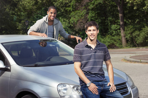 Teini-ikäiset pojat seisoo lähellä autoa
 - Valokuva, kuva