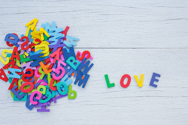 Colorful wooden alphabet and LOVE word. Top view on white wooden - Foto, Imagem