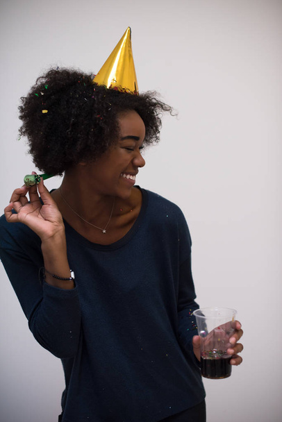 black woman in party hat blowing in whistle - Foto, afbeelding