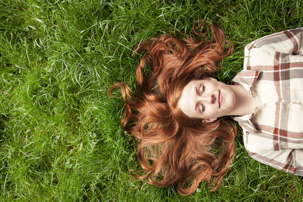 Teenage girl laying in grass - Photo, Image