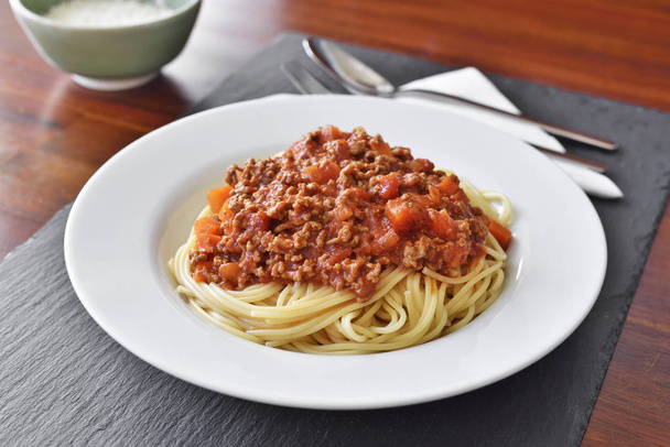 Спагетті Болоньєзе на білій тарілці
  - Фото, зображення