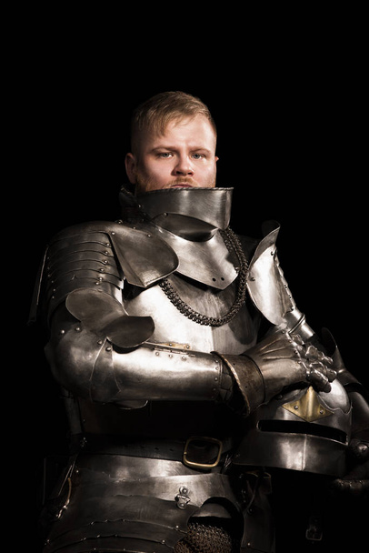 Knight in armour after battle on the black background - Foto, Bild