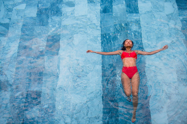 La photo aérienne d'un séduisant modèle sexy en maillot de bain blanc profite de la détente dans la piscine de l'hôtel pendant son week-end d'été. Femme de mode incroyable en bikini ayant un repos spa de luxe
 - Photo, image