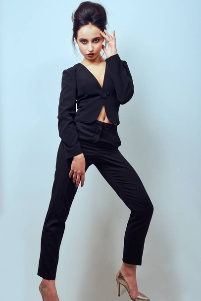 Sexy slim brunette woman posing in studio wearing fashionable jacket - Фото, зображення