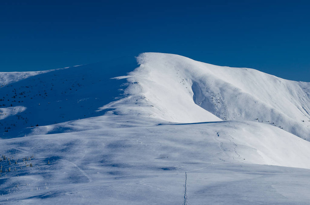 Minimalistinen talvinäkymä vuorelle
 - Valokuva, kuva