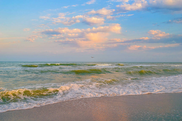 Vista panorámica de las olas del mar rodando en tierra al atardecer
 - Foto, Imagen