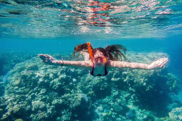 Girl in swimming mask diving in Red sea near coral reef - Photo, Image